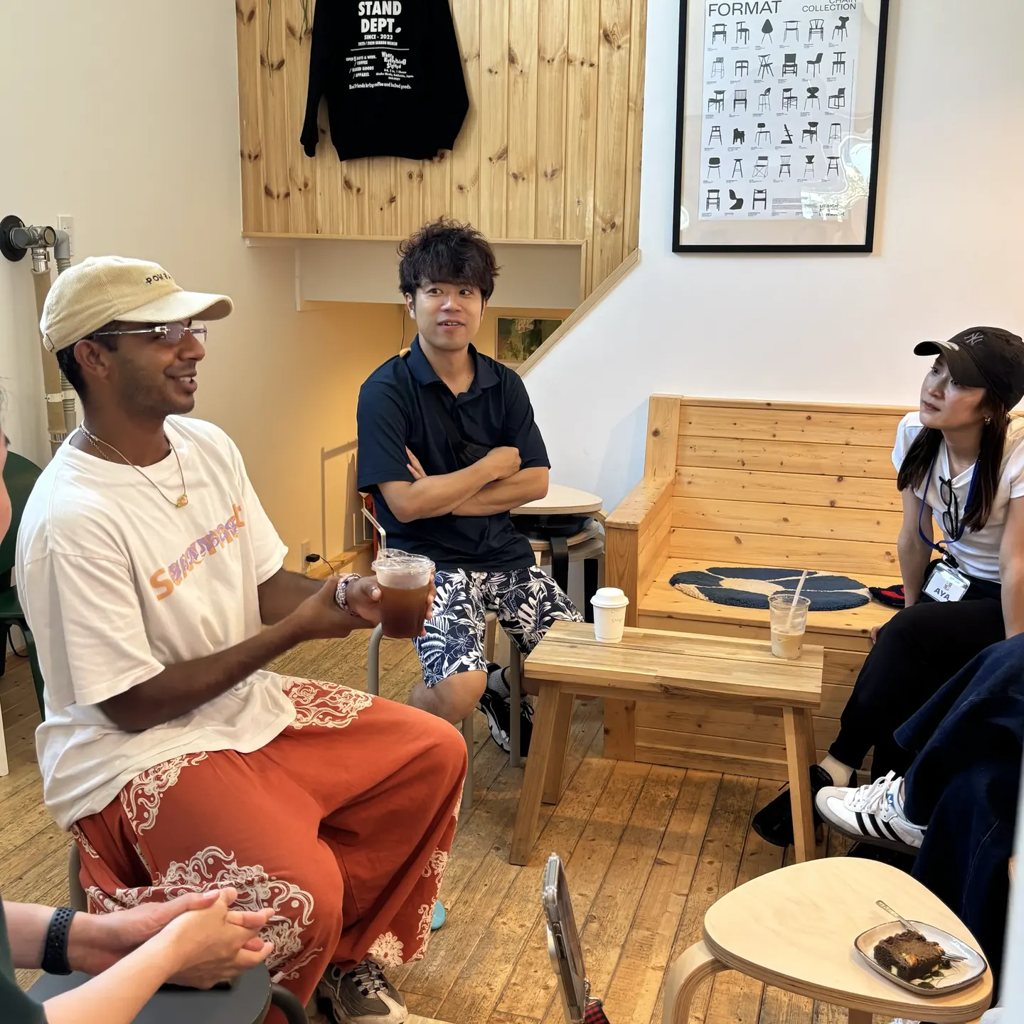 カフェのテーブルを囲んで、ネイティブ講師と生徒が英語で会話しているCafe Walkの様子