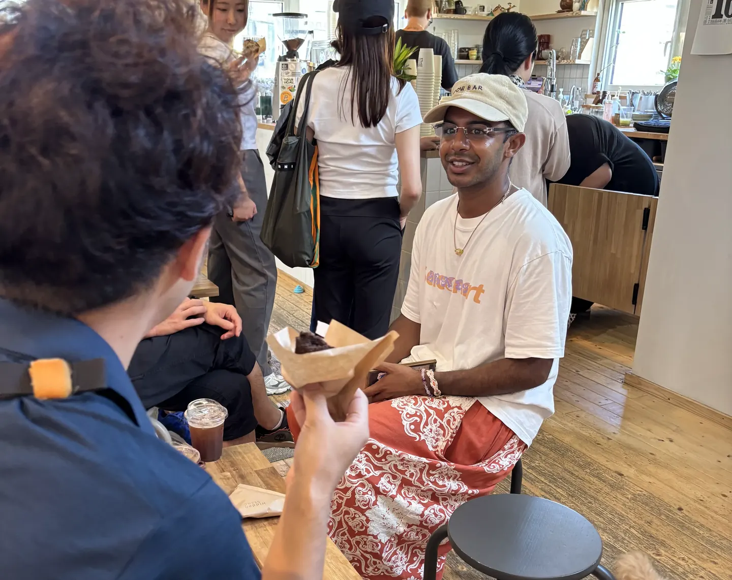 Cafe Walkでニセコのカフェを訪れ、英語で注文したドリンクとお菓子を受け取る生徒たち