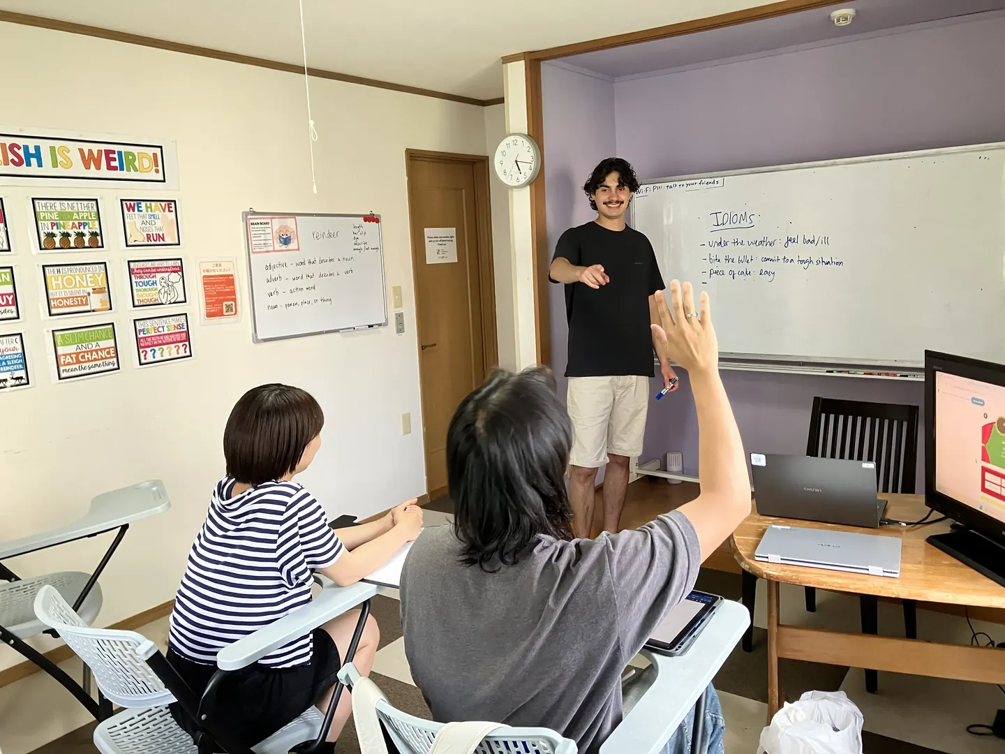 ニセコ留学の教室で、ネイティブ講師がホワイトボードにイディオムを書きながら少人数レッスンを行っている様子